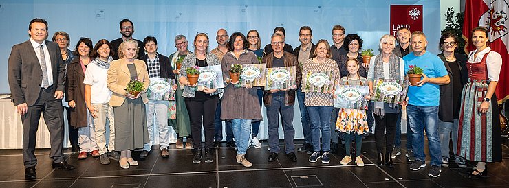 LR René Zumtobel (1.v.li.), Obfrau des Tiroler Bildungsforum Bettina Ellinger (1.v.re.) und Matthias Karader, Projektkoordinator Natur im Garten (5.v.li.), GemeindevertreterInnen und Natur im Garten BeraterInnen des Tiroler Bildungsforum mit Geehrten aus dem Bezirk Innsbruck-Land, Region Ost.