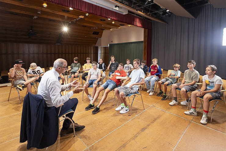 © Land Tirol/Die Fotografen LH Mattle sitzt in einem Sitzkreis zusammen mit den Kindern von Coding4kids.
