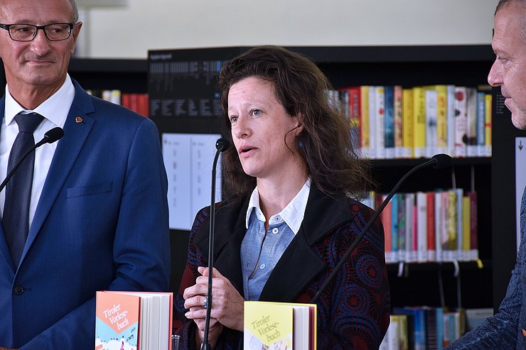 Sonja Altenburger vor dem Stehtisch zwischen dem Landeshauptmann und Bernhard Aichner