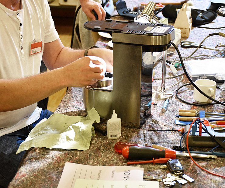 © Land Tirol/Feuersinger Person repariert Kaffeemaschine