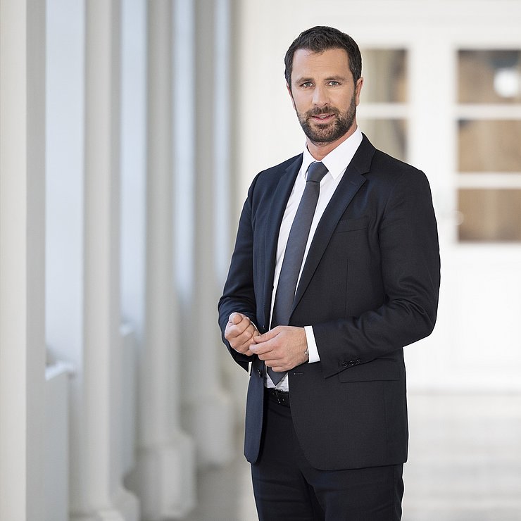© Land Tirol/Die Fotografen Portrait Dornauer in dunklem Anzug in Gang stehend