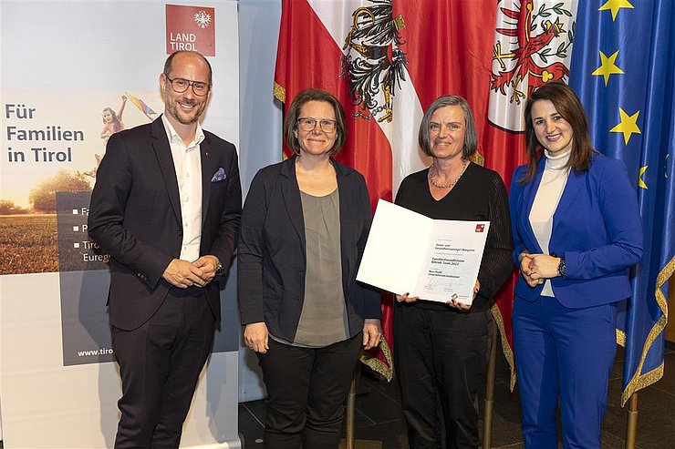 vier Personen mit Urkunde