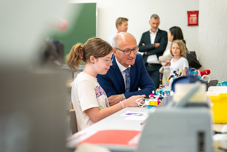 © Land Tirol/Järvinen LH Mattle und Kind vor Laborgeräten