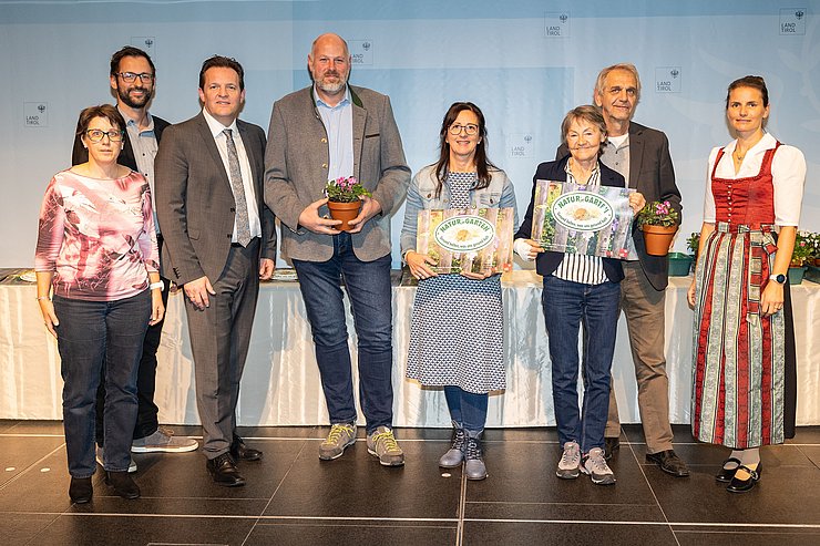 LR René Zumtobel (3.v.li.), Obfrau des Tiroler Bildungsforum Bettina Ellinger (1.v.re.) und Matthias Karader, Projektkoordinator Natur im Garten (1.v.li.), GemeindevertreterInnen und Natur im Garten BeraterInnen des Tiroler Bildungsforum mit Geehrten aus dem Bezirk Schwaz.
