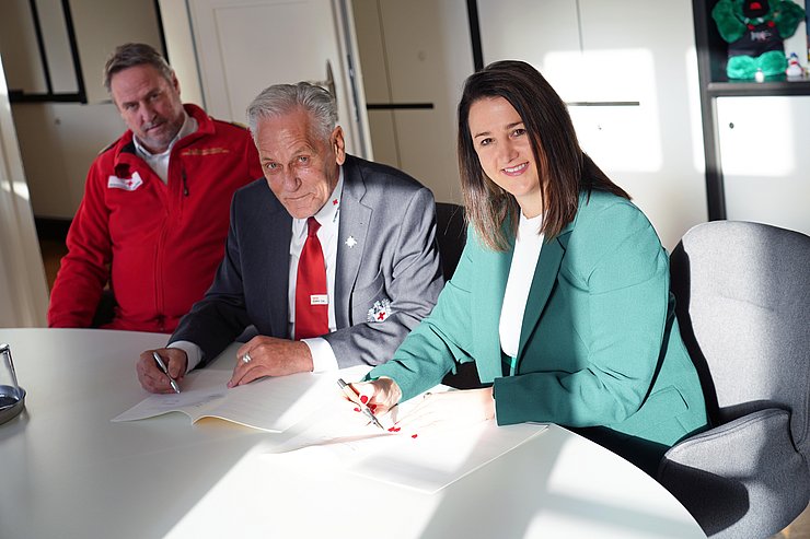 © Land Tirol/Neuner Mair und Ennemooser an Tisch sitzend, Vertrag unterschreibend, daneben sitzend Martin Dablander