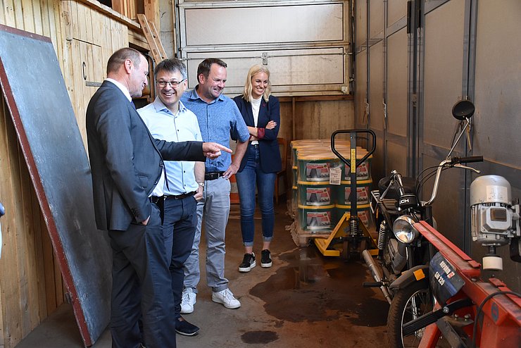 LHStv Geisler in Werkstatt mit mehreren Personen sprechend