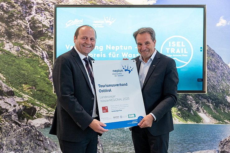 Zwei Menschen halten eine Urkunde in der Hand.