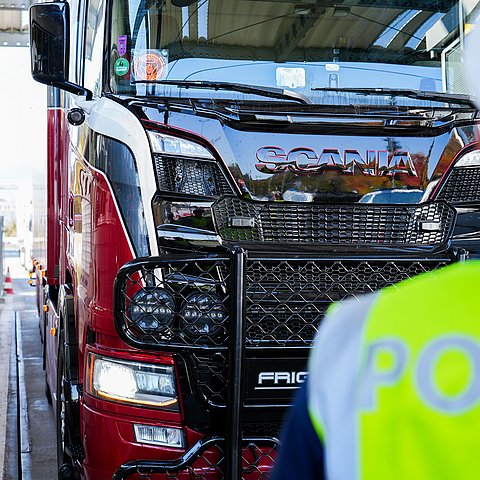 Lkw, im Vordergrund ein Polizist