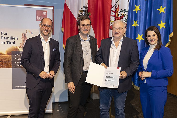 vier Personen mit Urkunde