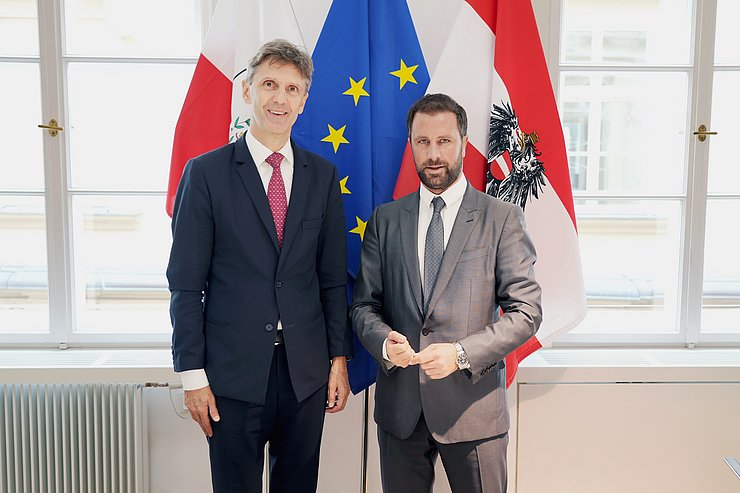 © Land Tirol/Neuner Personen stehen nebeneinander, dahinter Fahnen