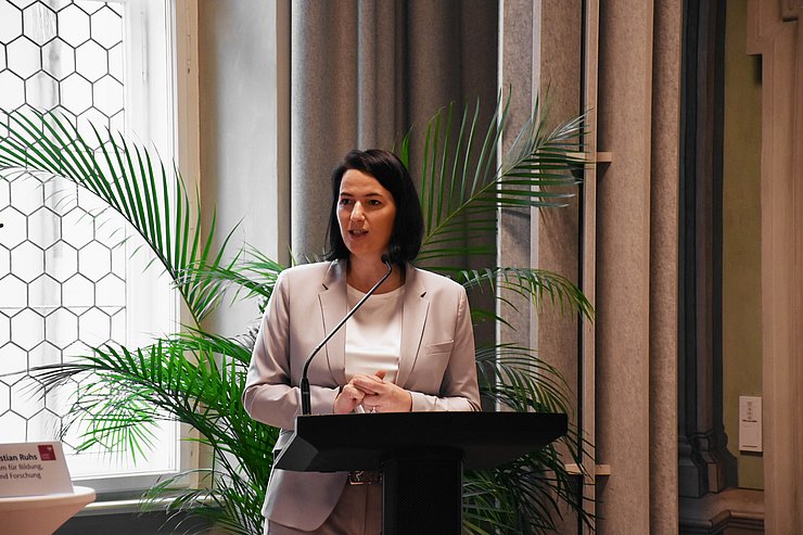 Frau steht vor Rednerpult und spricht