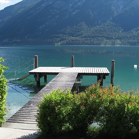 Ein Holzsteg, der in den Achensee hineinreicht.