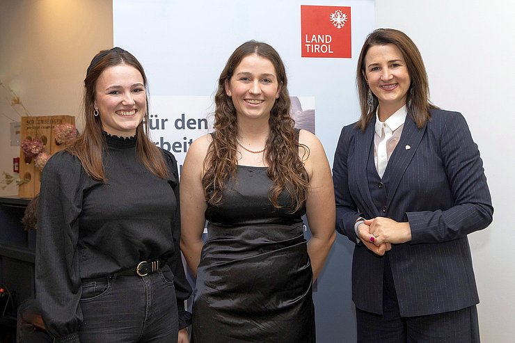 © Land Tirol/Die Fotografen Von links die bestausgezeichneten Lehrlinge Veronika Berger (Tapeziererin und Dekorateurin im dritten Lehrjahr bei der Firma Haidacher Gesellschaft mbH) und Sidney Dion Wörgötter (Fachfrau für Metalltechnik und Maschinenbautechnik im ersten Lehrjahr bei der Firma D. Swarovski KG) mit Gratulatin Arbeits- und Jugendlandesrätin Astrid Mair.
