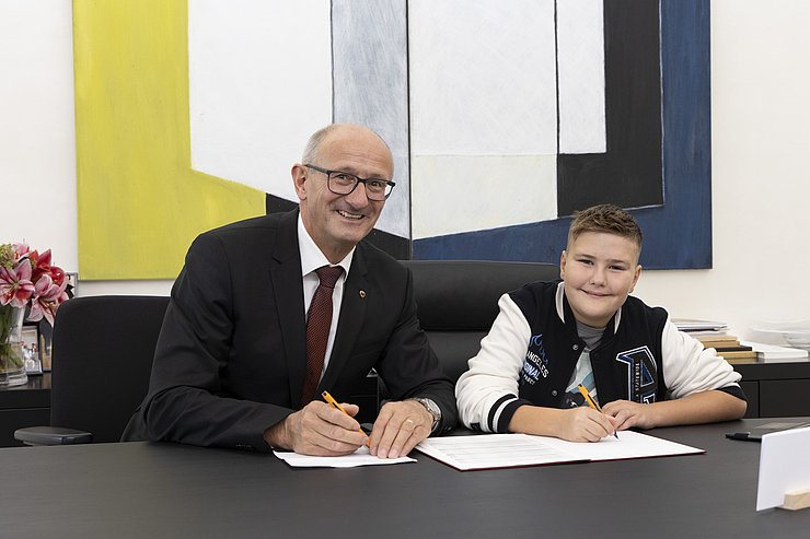 LH Anton Mattle sitzt mit Bub am Schreibtisch.