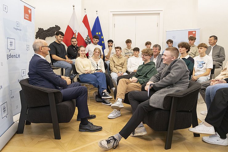 © Land Tirol/Die Fotografen LH Mattle sitzt vor der Schulklasse und beantwortet die Fragen der SchülerInnen.