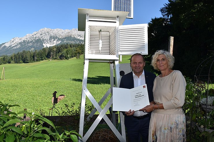 Josef Geisler und Angelika Leoni stehen mit der Urkunde vor der Messstelle.