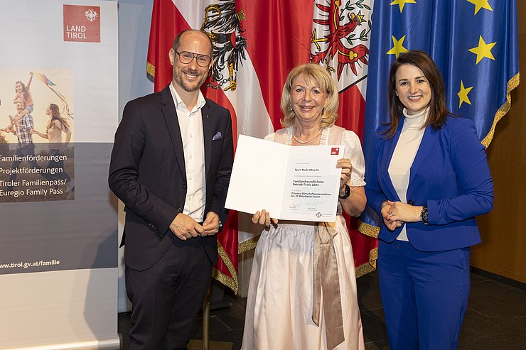 drei Personen mit Urkunde