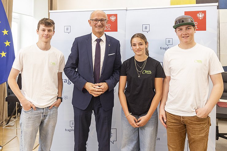 © Land Tirol/Die Fotografen Vier Menschen posieren vor einem Roll-Up.