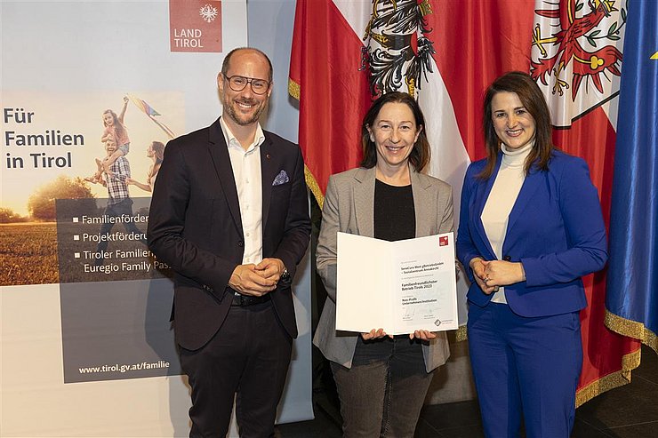 drei Personen mit Urkunde