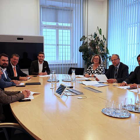 Menschen um Tisch sitzend