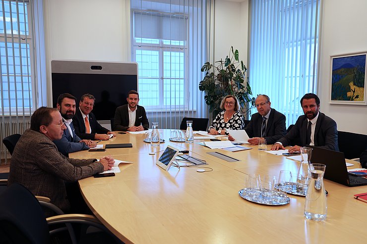 Menschen um Tisch sitzend