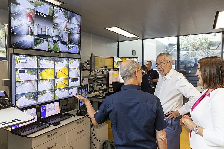 Noggler, Van der Bellen und Mair stehen vor Bildschirmen mit Tunnelüberwachung; Noggler zeigt auf Bildschirme und erklärt etwas