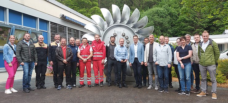 Die Teilnehmer des Vernetzungstreffen vor einer ausgemusterten Pelton-Turbine