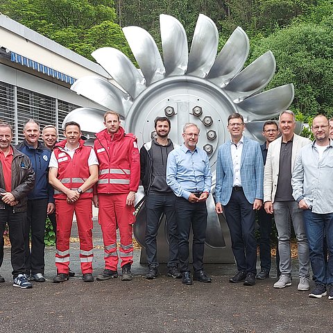 Die Teilnehmer des Vernetzungstreffen vor einer ausgemusterten Pelton-Turbine