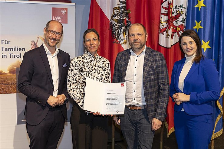 vier Personen mit Urkunde