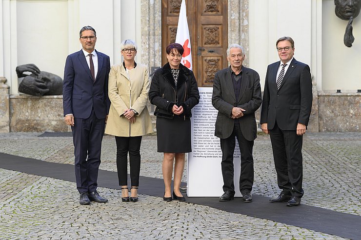 © Landtagsdirektion Tirol/Berger (v.li.) LH Arno Kompatscher, LRin Giulia Zanotelli, LTPin Sonja Ledl-Rossmann, Felix Mitterer und LH Günther Platter auf der symbolischen Grenzlinie, die durch die Fahne der Euregio durchbrochen wird.