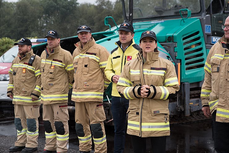 © Landesfeuerwehrverband Tirol/Wegscheider Mair in Feuerwehrjacke neben Feuerwehrmännern stehend