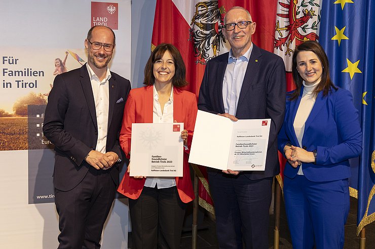 vier Personen mit Urkunde