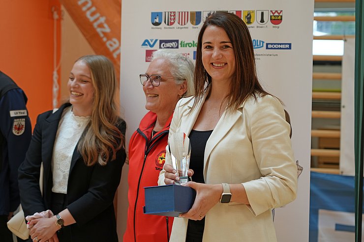 © Land Tirol/Reiter Eine Frau hält einen Pokal in der Hand.