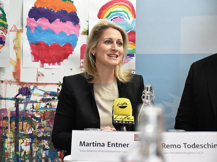 © Land Tirol/Hörmann Foto von einer Frau vor einer bunt bemalten Wand