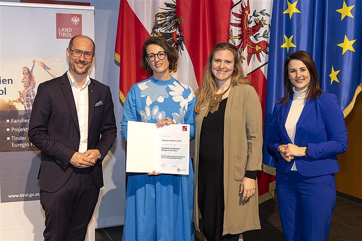 vier Personen mit Urkunde