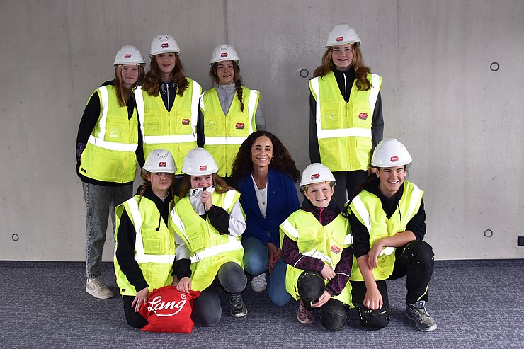 Gruppenfoto - Schülerinnen tragen gelbe Warnwesten und Helme