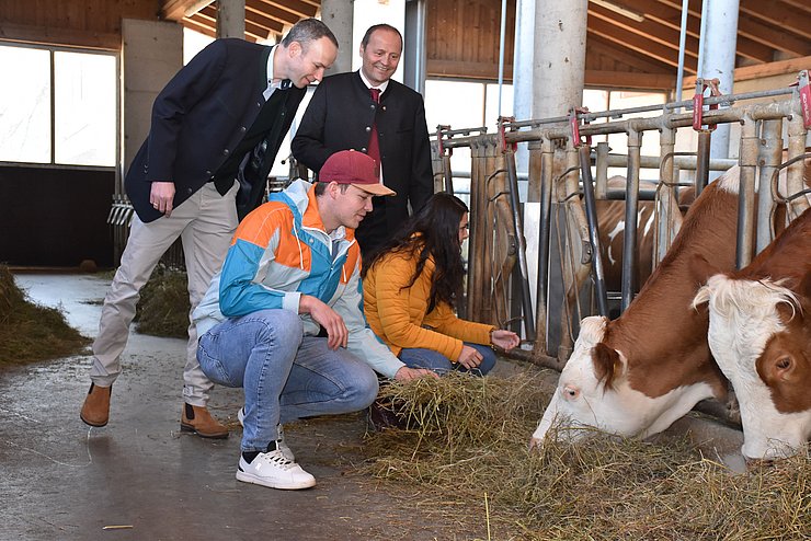 Khol und Geisler mit zwei Jugendlichen im Stall, füttern Kühe