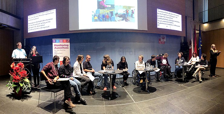 © Land Tirol/Wahl Panoramafoto: Rednerpult, Mitglieder des Kinder- und Jugendprojektes, Gebärdensprachdolmetscherin