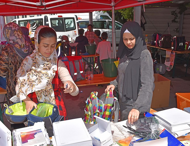 Ayslwerberinnen beim befüllen der Schultaschen
