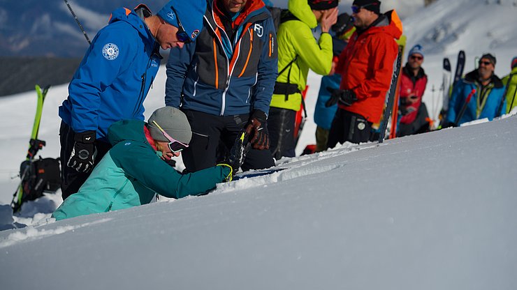 © Land Tirol Frau im Schnee gräbt Schneeprofil