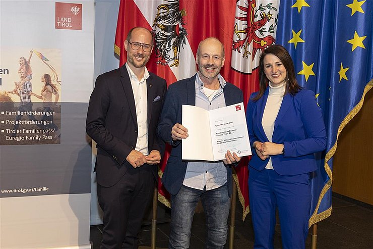 drei Personen mit Urkunde