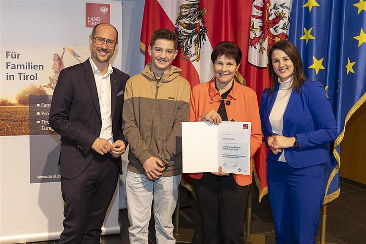 vier Personen mit Urkunde