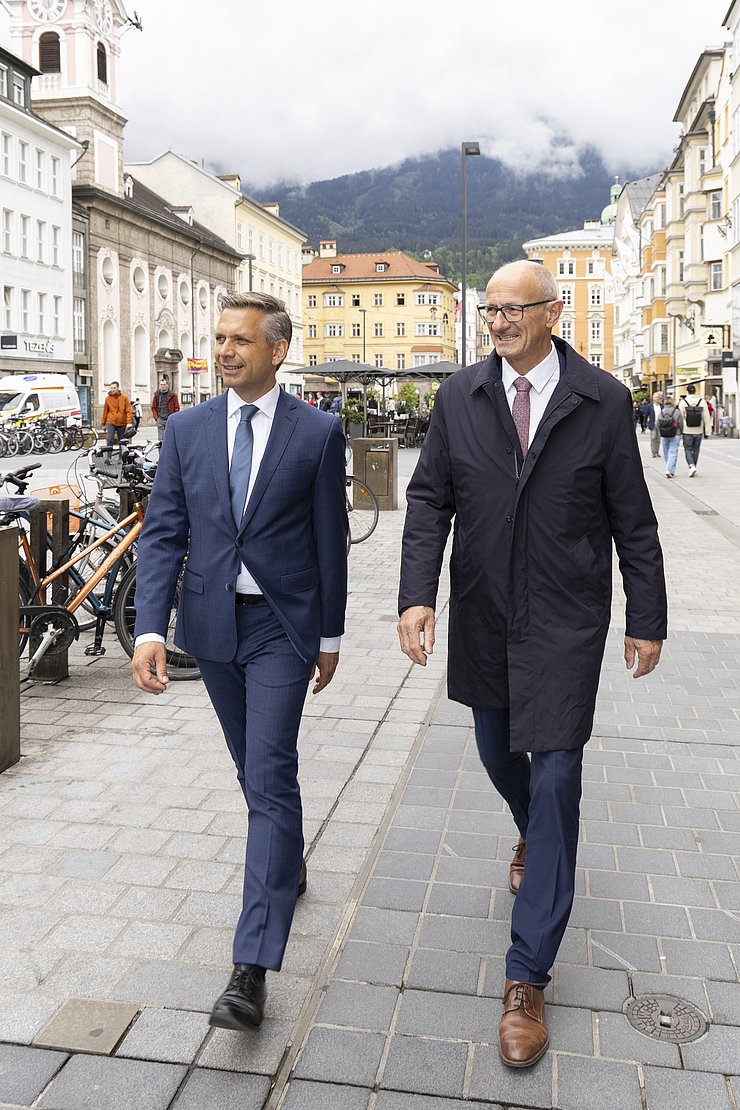Zwei Menschen gehen eine Straße entlang.
