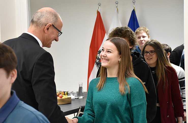 Der Landeshauptmann begrüßt händeschüttelnd einen Lehrling.