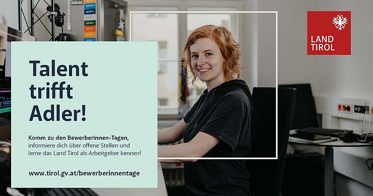 Auf dem Bild ist ein Frau in einem Büro zu sehen welche in die Kamera lächelt. 