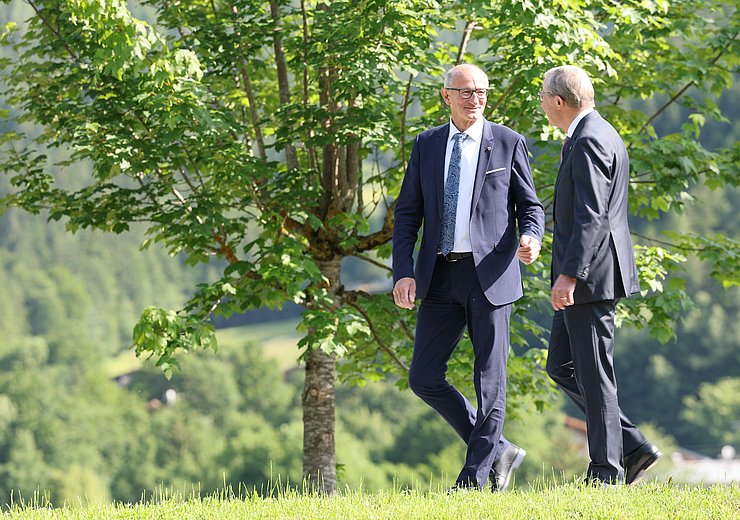 LH Anton Mattle im Gespräch mit Salzburgs Landeshauptmann Wilfried Haslauer auf Wiese stehend