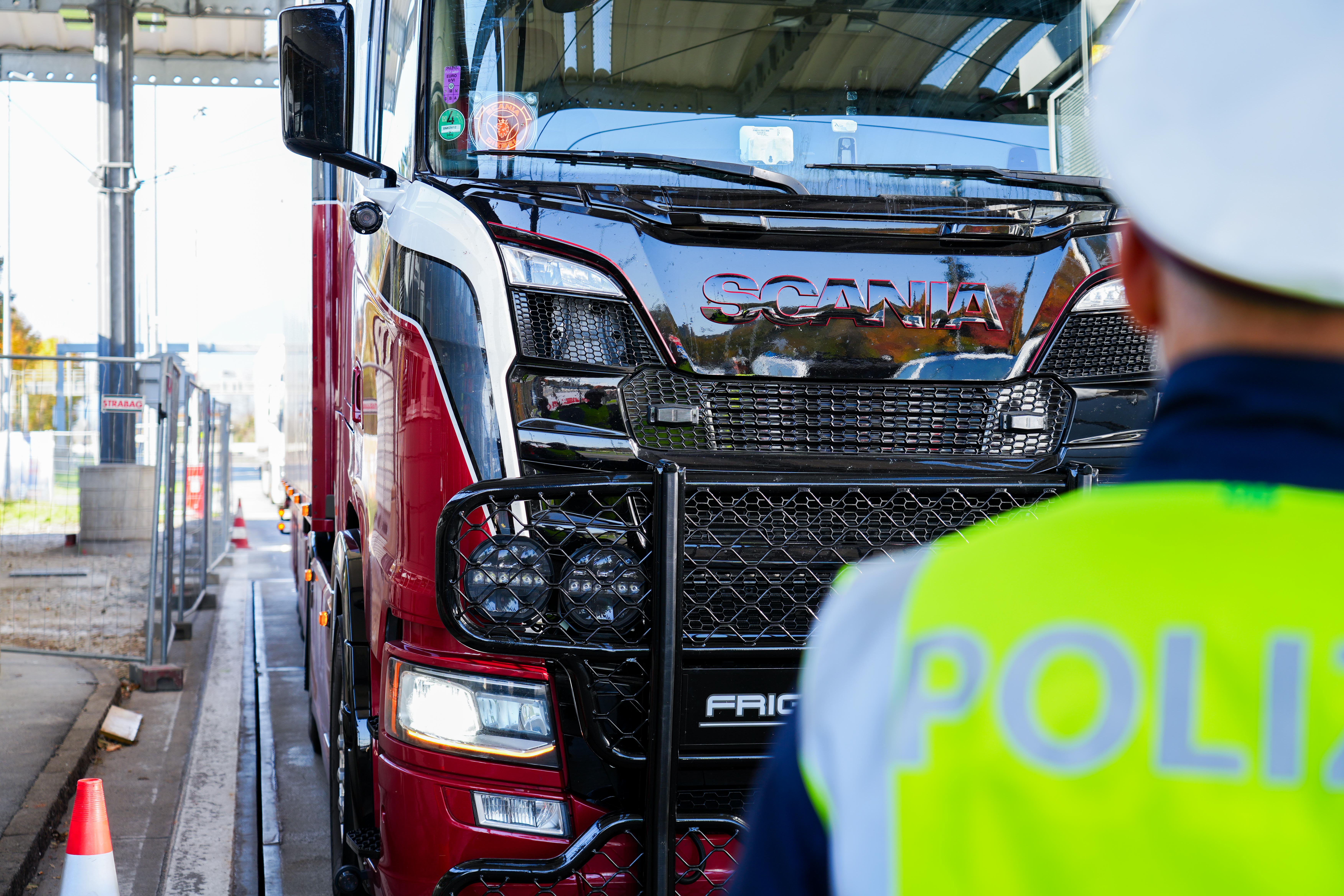 Lkw, im Vordergrund ein Polizist